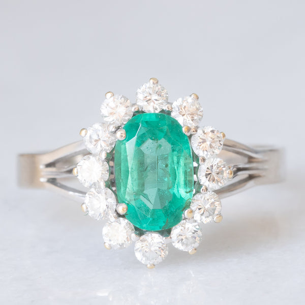 Anello a margherita in oro bianco 18K con smeraldo (1ct ca.) e diamanti di taglio brillante (0.50ctw ca.), anni ‘60
