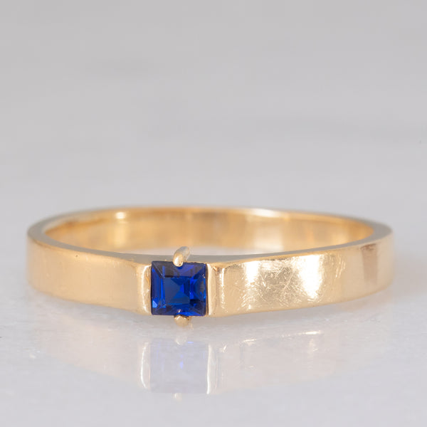 Solitario a fascia vintage in oro giallo 14K con zaffiro di taglio carré (0.18ct ca.), anni ‘70