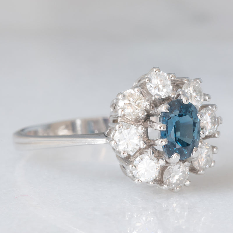 Anello a margherita vintage in oro bianco 14K con zaffiro (0.75ct ca.) e diamanti di taglio brillante (0.64ctw ca.), anni ‘60/‘70