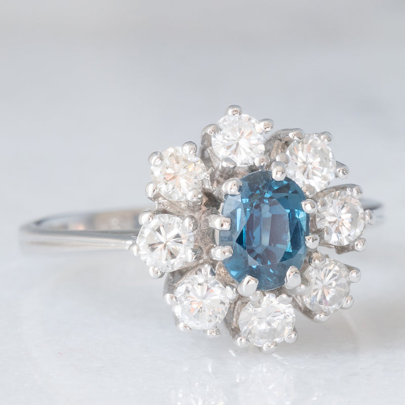 Anello a margherita vintage in oro bianco 14K con zaffiro (0.75ct ca.) e diamanti di taglio brillante (0.64ctw ca.), anni ‘60/‘70