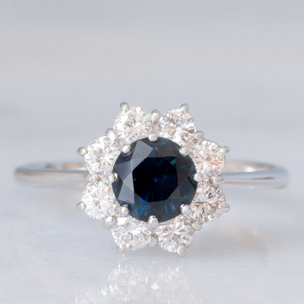 Anello a margherita vintage in oro bianco 18K con zaffiro (1.20ct ca.) e diamanti di taglio brillante (0.80ctw ca.), anni ‘70