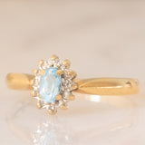 Anello a margherita vintage in oro giallo 9K con topazio azzurro (0.30ct ca.) e diamanti (0.06ctw ca.), anni ‘80