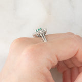 Anello a margherita vintage in oro bianco 18K con smeraldo (0.50ct ca.) e diamanti di taglio brillante (1.20ctw ca.), anni ‘60/‘70