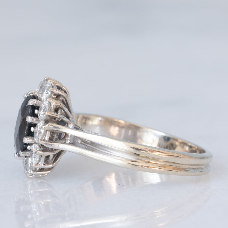 Anello a margherita vintage in oro bianco 18K con zaffiro (1ct ca.) e diamanti di taglio brillante (0.60ctw ca.), anni ‘70