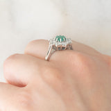Anello a margherita vintage in oro bianco 18K con smeraldo (0.50ct ca.) e diamanti di taglio brillante (1.20ctw ca.), anni ‘60/‘70