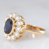 Anello a margherita vintage in oro 18K con zaffiro (1.10ct ca.) e diamanti di taglio brillante (0.50ctw ca.), anni ‘60