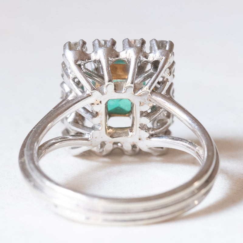 Anello a margherita francese vintage in platino e in oro bianco 18K con smeraldo (0.90ct ca.) e diamanti (0.70ctw ca.), anni ‘50/‘60