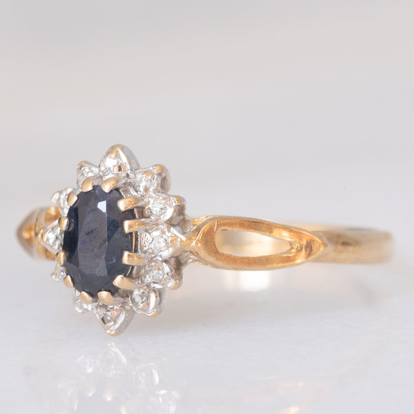 Anello a margherita vintage in oro giallo e bianco 9K con zaffiro (0.60ct ca.) e diamanti (0.06ctw ca.), anno 1988