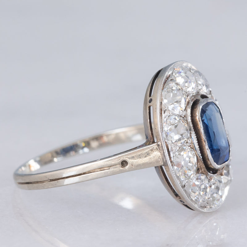 Anello a margherita antico in oro bianco con zaffiro (0.70ct ca.) e diamanti di taglio vecchia miniera (1ctw ca.), anni ‘20/‘30