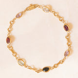 Bracciale vintage in oro giallo 18K con granati, ametiste, acquamarina, spinello blu sintetico e zaffiro bianco, anni ‘70