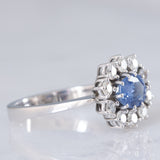 Anello a margherita in oro bianco 18K con zaffiro azzurro (0.80ct ca.) e diamanti di taglio brillante (0.70ctw ca.), anni ‘70/‘80