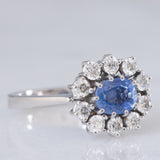 Anello a margherita in oro bianco 18K con zaffiro azzurro (0.80ct ca.) e diamanti di taglio brillante (0.70ctw ca.), anni ‘70/‘80