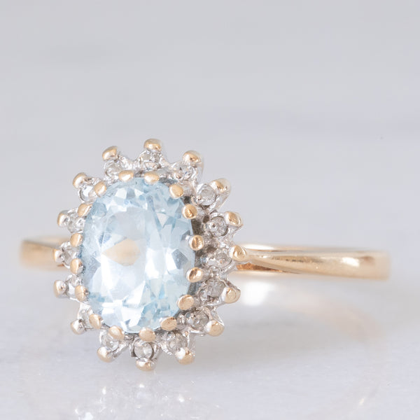 Anello a margherita vintage in oro giallo e bianco 9K con topazio azzurro (1.60ct ca.) e diamanti (0.16ctw ca.), anni ‘80