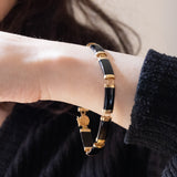 Halbstarres Vintage-Onyx-Armband aus 14-karätigem Gelbgold mit chinesischem Schriftverschluss aus 14-karätigem Gelbgold, 70er Jahre