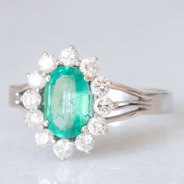 Anello a margherita in oro bianco 18K con smeraldo (1ct ca.) e diamanti di taglio brillante (0.50ctw ca.), anni ‘60