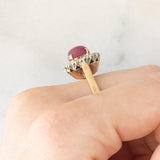Anello a margherita vintage in oro giallo e bianco 14K con rubino (2.60ct ca.) e diamanti di taglio brillante (0.70ctw ca.), anni ‘60