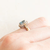 Anello a margherita vintage in oro giallo e bianco 9K con topazio azzurro (0.60ct ca.) e diamanti (0.16ctw ca.), anno 1992