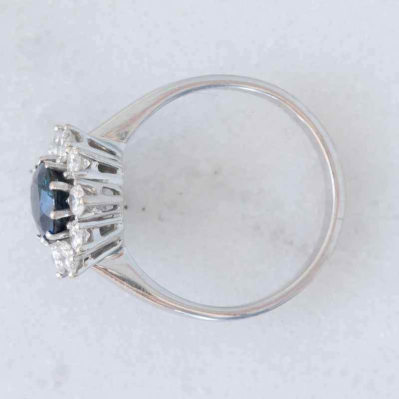 Anello a margherita vintage in oro bianco 18K con zaffiro (1.90ct ca.) e diamanti di taglio brillante (0.75ctw ca.), anni ‘70