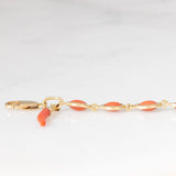 Pulseira vintage em ouro amarelo 18K com coral laranja e fecho decorado com um pingente de chifre da sorte, década de 70