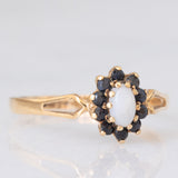 Vintage-Gänseblümchenring aus 9-karätigem Gelbgold mit Opal (ca. 0.15 ct) und Saphiren (ca. 0.20 ctw), Jahr 1986