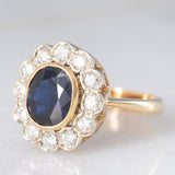 Anello a margherita vintage in oro 18K con zaffiro (1.10ct ca.) e diamanti di taglio brillante (0.50ctw ca.), anni ‘60