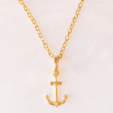 Collana con catenina in argento dorato e con tre ciondoli a forma di delfino in oro giallo 18K, di ancora in oro giallo 18K e di tartaruga in oro giallo 14K
