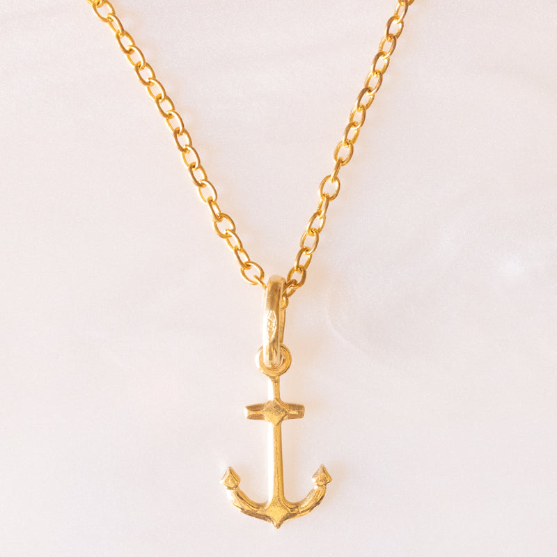 Collana con catenina in argento dorato e con tre ciondoli a forma di delfino in oro giallo 18K, di ancora in oro giallo 18K e di tartaruga in oro giallo 14K