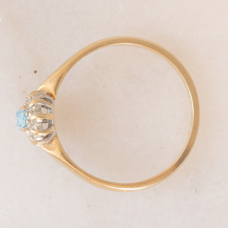 Anello a margherita vintage in oro giallo 9K con topazio azzurro (0.30ct ca.) e diamanti (0.06ctw ca.), anni ‘80