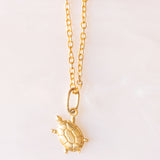 Collana con catenina in argento dorato e con tre ciondoli a forma di delfino in oro giallo 18K, di ancora in oro giallo 18K e di tartaruga in oro giallo 14K