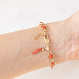 Pulseira vintage em ouro amarelo 18K com coral laranja e fecho decorado com um pingente de chifre da sorte, década de 70