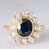 Anello a margherita vintage in oro 18K con zaffiro (1.10ct ca.) e diamanti di taglio brillante (0.50ctw ca.), anni ‘60