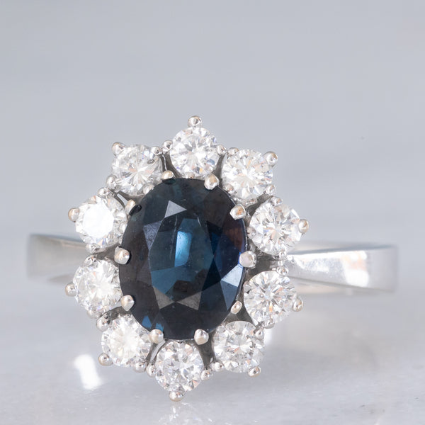 Anello a margherita vintage in oro bianco 18K con zaffiro (1.90ct ca.) e diamanti di taglio brillante (0.75ctw ca.), anni ‘70