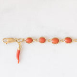 Pulseira vintage em ouro amarelo 18K com coral laranja e fecho decorado com um pingente de chifre da sorte, década de 70
