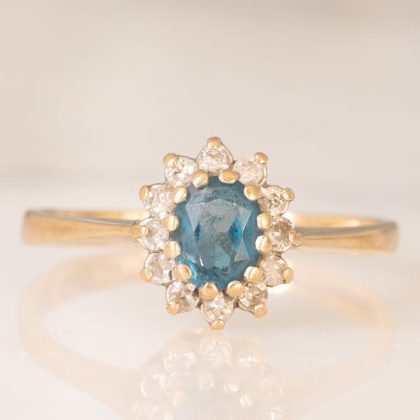Anello a margherita in oro giallo 9K con topazio azzurro (0.35ct ca.) e diamanti (0.12ctw ca.), anni ‘90