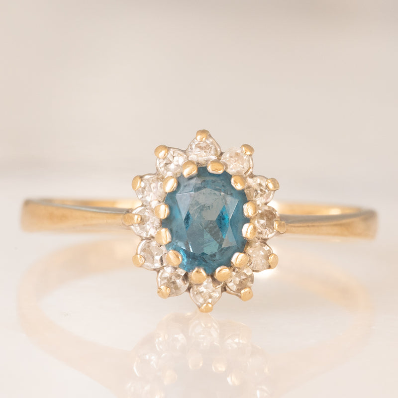 Anello a margherita in oro giallo 9K con topazio azzurro (0.35ct ca.) e diamanti (0.12ctw ca.), anni ‘90