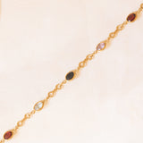 Bracciale vintage in oro giallo 18K con granati, ametiste, acquamarina, spinello blu sintetico e zaffiro bianco, anni ‘70