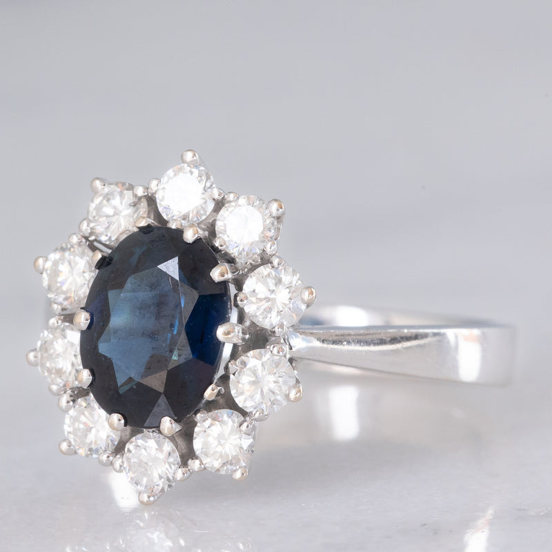 Anello a margherita vintage in oro bianco 18K con zaffiro (1.90ct ca.) e diamanti di taglio brillante (0.75ctw ca.), anni ‘70