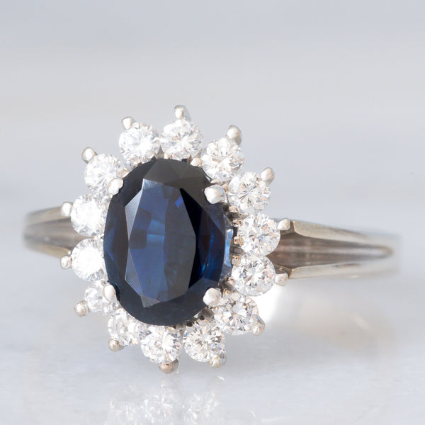 Anello a margherita in oro bianco 18K con zaffiro (1.30ct ca.) e diamanti di taglio brillante (0.44ctw ca.), anni ‘70
