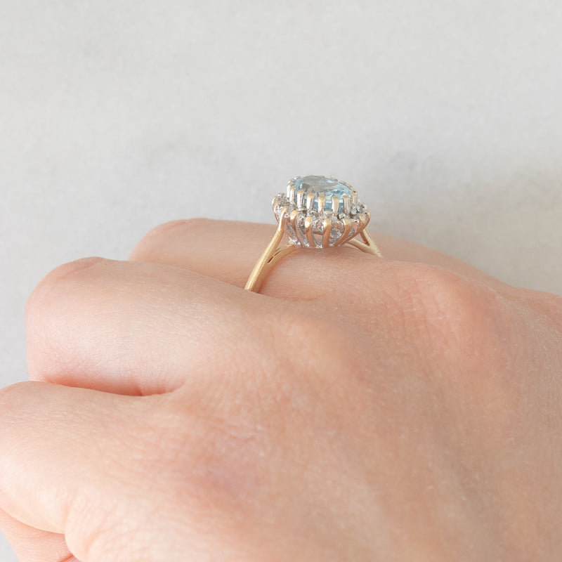 Anello a margherita vintage in oro giallo e bianco 9K con topazio azzurro (1.60ct ca.) e diamanti (0.16ctw ca.), anni ‘80