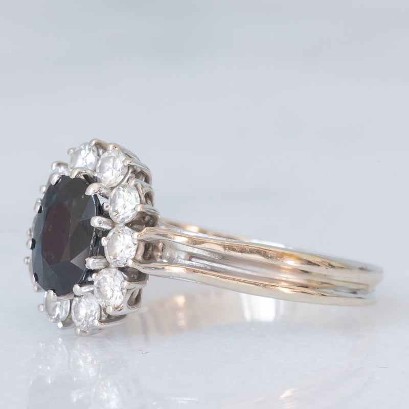 Anello a margherita vintage in oro bianco 18K con zaffiro (1ct ca.) e diamanti di taglio brillante (0.60ctw ca.), anni ‘70