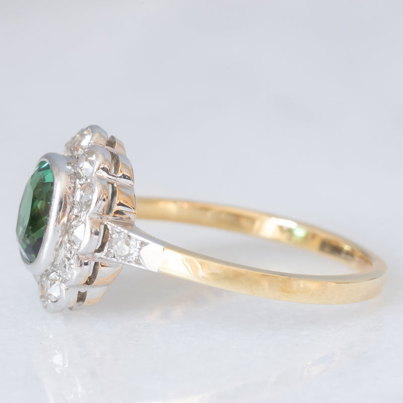 Anello a margherita antico in oro giallo 18K con tormalina verde (1ct ca.) e diamanti di taglio vecchia miniera (0.50ctw ca.), anni ‘20/‘30