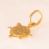 Collana con catenina in argento dorato e con tre ciondoli a forma di delfino in oro giallo 18K, di ancora in oro giallo 18K e di tartaruga in oro giallo 14K