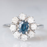 Anello a margherita vintage in oro bianco 14K con zaffiro (0.75ct ca.) e diamanti di taglio brillante (0.64ctw ca.), anni ‘60/‘70