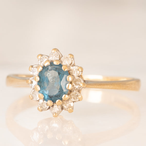 Anello a margherita in oro giallo 9K con topazio azzurro (0.35ct ca.) e diamanti (0.12ctw ca.), anni ‘90