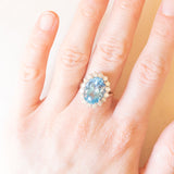 Vintage 9K yellow and white gold daisy ring with blue topaz (approx. 7.50ct) and brilliant cut diamonds (approx. 0.96ctw), 1998