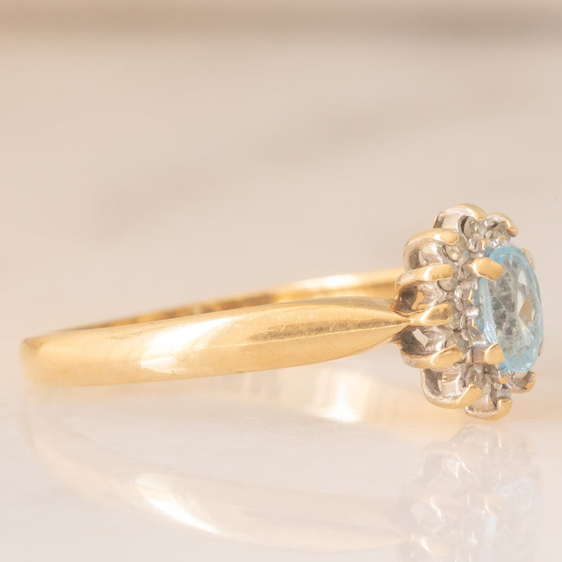 Anello a margherita vintage in oro giallo 9K con topazio azzurro (0.30ct ca.) e diamanti (0.06ctw ca.), anni ‘80