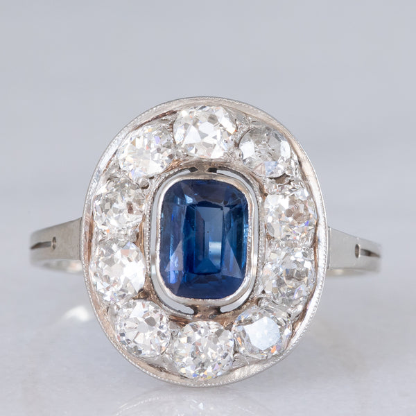 Anello a margherita antico in oro bianco con zaffiro (0.70ct ca.) e diamanti di taglio vecchia miniera (1ctw ca.), anni ‘20/‘30