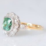 Anello a margherita antico in oro giallo 18K con tormalina verde (1ct ca.) e diamanti di taglio vecchia miniera (0.50ctw ca.), anni ‘20/‘30