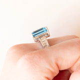 Anel de coquetel vintage em ouro branco 18K com topázio azul (aprox. 8.50 ct) e diamantes lapidação baguete (aprox. 0.80 ctw), década de 80