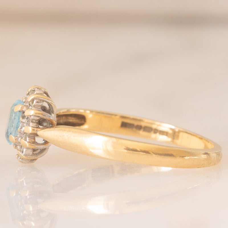 Anello a margherita vintage in oro giallo 9K con topazio azzurro (0.30ct ca.) e diamanti (0.06ctw ca.), anni ‘80